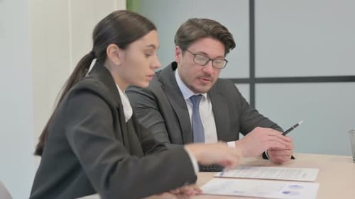 Business People Discussing Business Report in Office, Paperwork