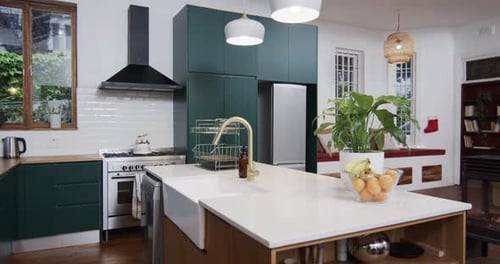 General view of modern kitchen with countertop, cupboards and kitchen equipment, slow motion