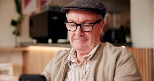 Coffee shop, morning and senior man with phone for internet, online games and chat in cafe