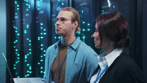 Workers Discuss Technology in Glowing Data Center