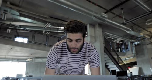 Man works at laptop in modern open office