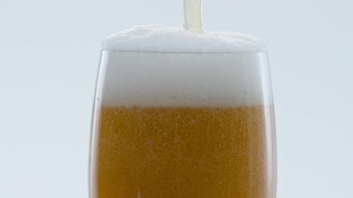 Beer Being Poured Into Glass With Foamy Head