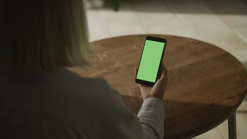 Person Holding Smartphone with Vertical Green Screen
