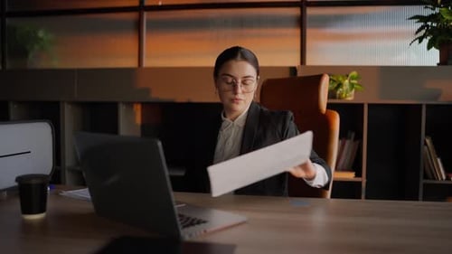 Woman Working at Desk with Laptop and Charts