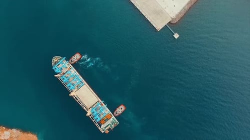 Bird's eye view of a cargo ship entering a container port