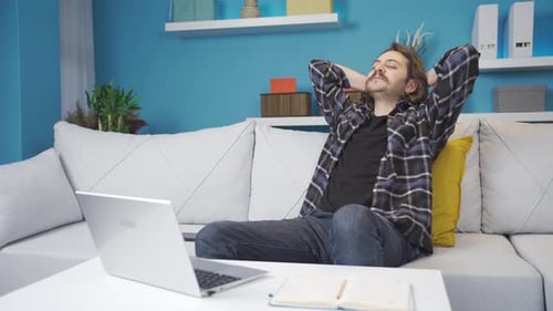 Mann arbeitet zu Hause am Laptop. Glücklich und zufrieden.
