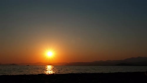 Person Silhouette Walking Towards Ocean at Sunset