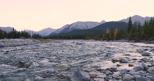 Tranquil River Flowing Over Rocks Below Scenic Mountain Range 10 Seconds or Greater