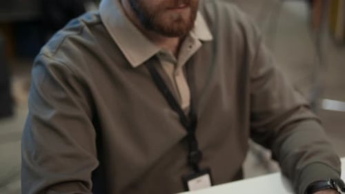 Developer in Eyeglasses Typing on Keyboard while Coding on Computer in Office