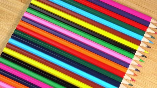 Colorful Pencils Lined Up on Wooden Surface