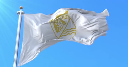 White Flag with Gold Emblem Waving in Blue Sky