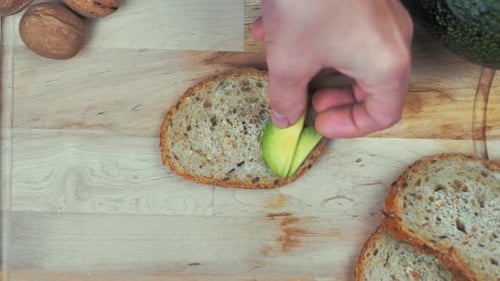 Preparing Avocado Toast on Wooden Cutting Board