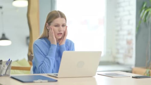 Distraught Woman Working At Computer in Office