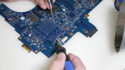 Technician Repairing Computer Circuit Board with Soldering Iron