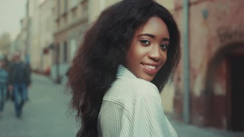 Woman Smiling Confidently Elegant Woman in Casual Attire Poses with Serene Expression Against City