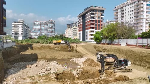 Excavator Moving Dirt at Construction Site in City