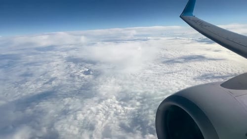 View through an airplane window on the sky and clouds.