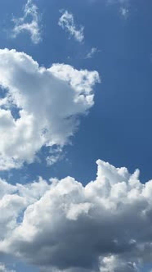 Little soft clouds grow big. Transformation of cloudscape in the blue sky. Timelapse. Vertical video