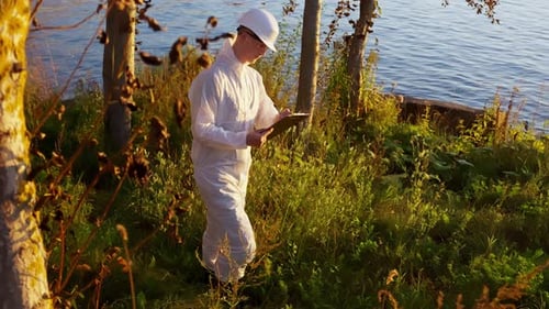 Environmental Scientist Taking Notes Near Lake