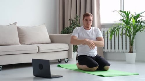 Selfcare während des Aufenthalts zu Hause: Fitnesstraining, Dehnübungen online, Männer zu Hause mit Laptop