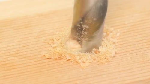 Drill Bit Drilling Hole in Wood Plank