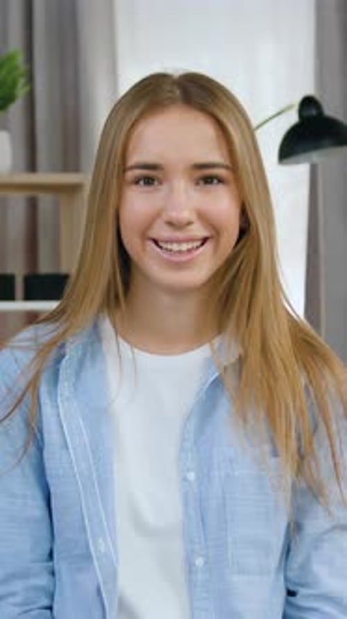 Belle blonde moderne de 20 ans, joyeuse et insouciante, vêtue d'une tenue tendance, assise sur une jolie décoration