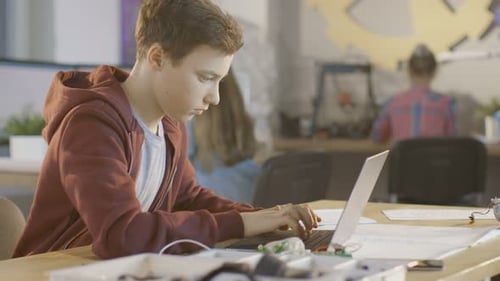 Smart Bot Uses Laptop at School Working on a Project Writing Paper.