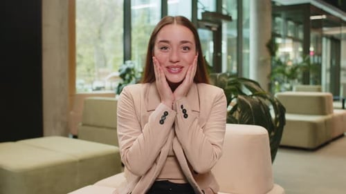 Caucasian Young Businesswoman Lady Looking at Camera Shocked By Sudden Victory in Office Lobby