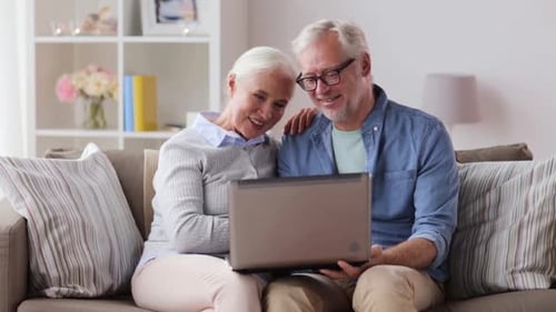 Senior Couple Using Laptop Together on Sofa at Home
