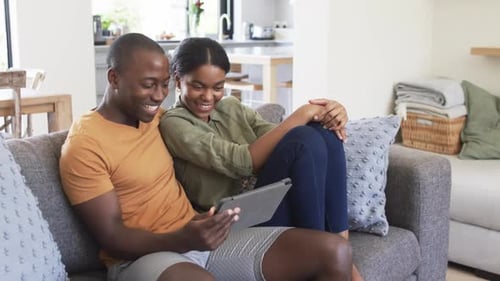 Couple Relaxing Indoors Using Tablet