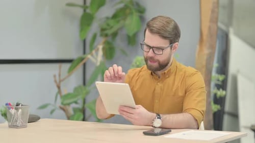 Man Using Tablet Device at Desk in Office