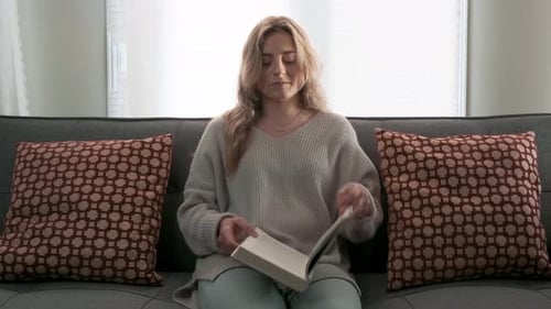Woman Reading Book on Couch at Home