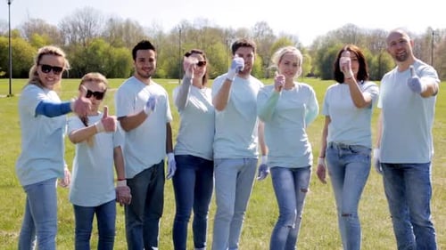 Volunteers Giving Thumbs Up in a Sunny Park