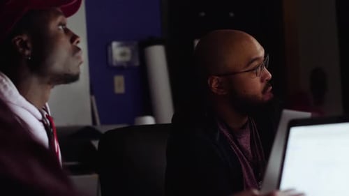Hackers hablan de trabajar en computadoras portátiles durante un hackatón en Dark Office entre 25 y 29 años