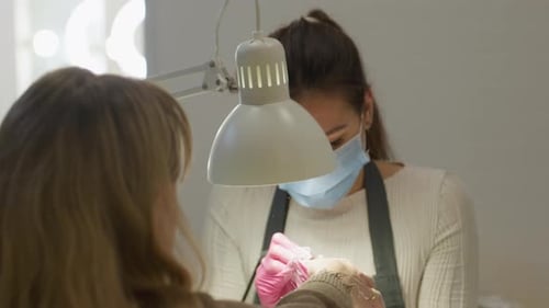 Manicurist Files Nails in Beauty Salon Close Up