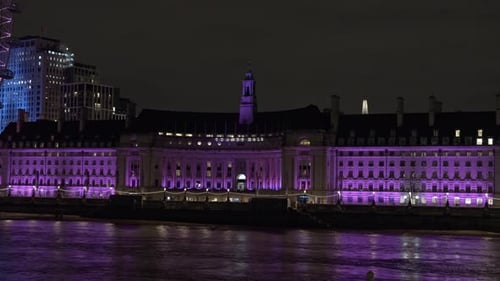 County Hall illuminated at night along River Thames, London