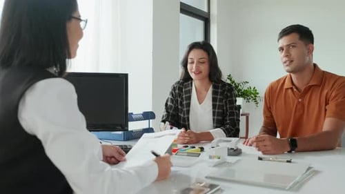 Young Married Couple Visiting Insurance Agent in Office