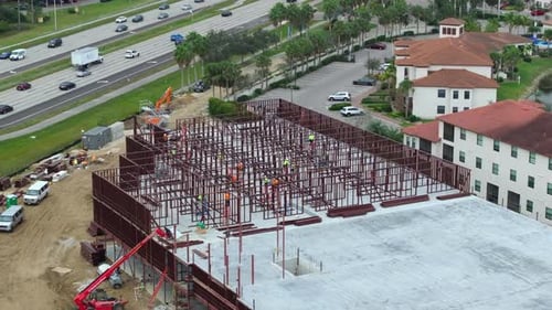 Bauarbeiten an Metallwänden von Büroarbeitern eines Geschäftshauses auf einer großen Baustelle mit
