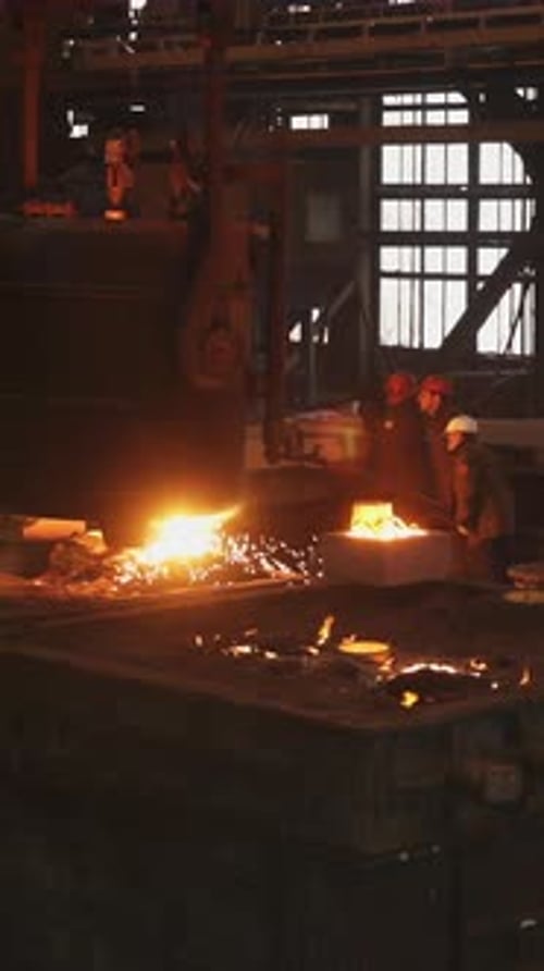 Foundry Workers Pouring Molten Metal in Large Industrial Mold Stock Clip