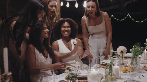Bride Showing Off Ring with Friends at Night