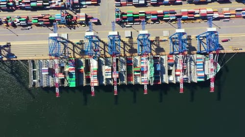 Aerial View of Giant Cargo Ship Loading at Busy Port