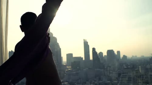 Man Dressed in Shirt in Apartment Overlooking City
