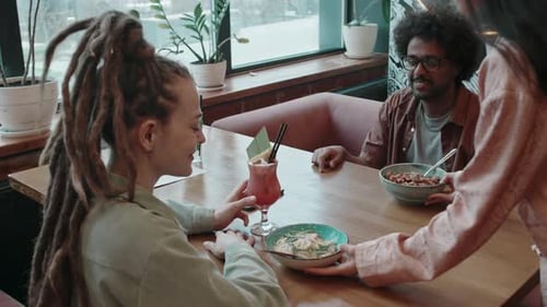 Friends Sitting Opposite Each Other in Cafe, Waiting for Waitress to Bring Food