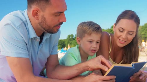 Family Reading a Book Together on the Beach