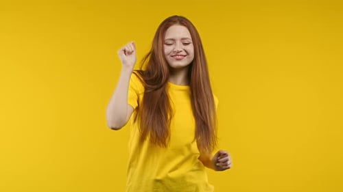 Pretty Positive Woman Having Fun Smiling Dancing in Studio on Yellow Background