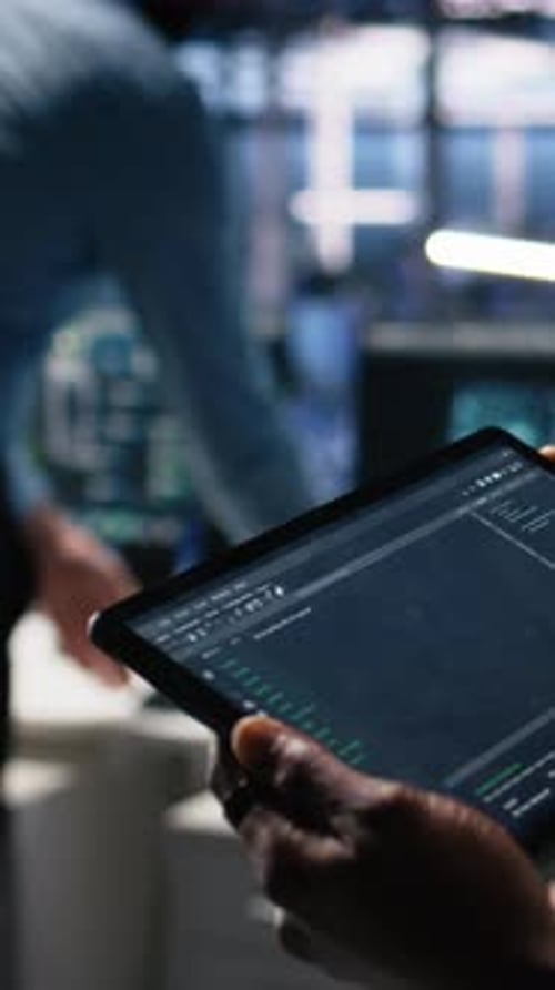 Vertical Video Close Up of Data Center Software Developer Using Tablet to Review Code