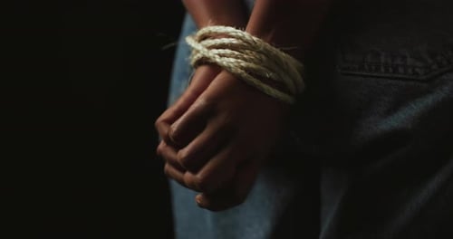 Hands, rope and prisoner for hostage, victim and escape isolated on black background