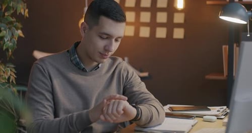 Slow Motion of Young Man Entrepreneur Using Smart Watch Touching Display Working Online in Office at