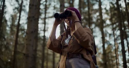Woman Exploring the Forest with Binoculars