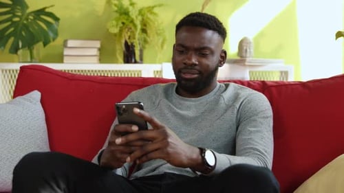 Man Using Mobile Phone While Relaxing on Couch